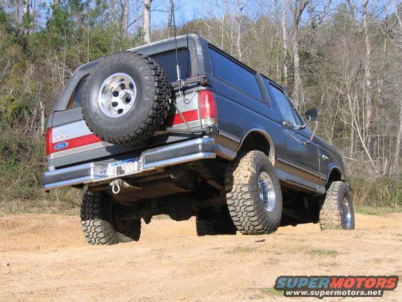 Ford Bronco on dirt with spare tire on back. License plate reads 6 B 3701