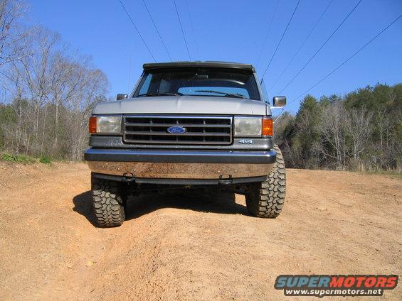 Silver Ford Bronco with off-road tires on a dirt path