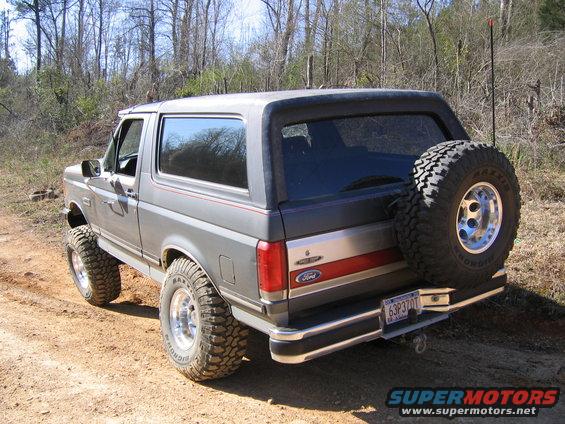 Gray Ford Bronco with lifted suspension and large tires parked on a dirt road