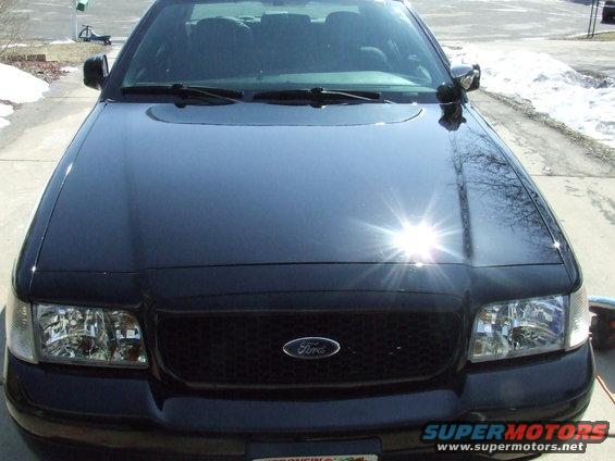 Black 2003 Ford Crown Victoria front grille with Ford logo, headlights, and hood