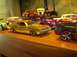 1970 Ford Ranchero - A collection of toy cars displayed on a shelf, a gold model in the foreground.