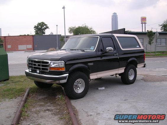 Black Ford Bronco with tan trim parked on a street