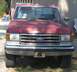 1989 Ford F-250 - This red Ford F-250 truck shows signs of wear and tear, with a cracked windshield and a visible "DIESEL" badge on the front.