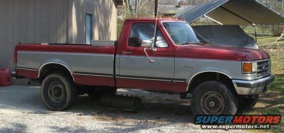 Red and silver 1987 Ford F-250 pickup truck, side view