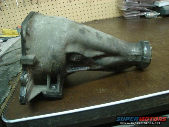 Gray metal transmission housing on a workbench, angled view