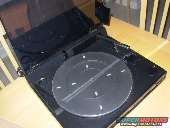 kd77fshattered07.jpg 16 days after it was mailed by USPS Priority from Michigan (2 day service), and 4 days after I got the first attempted delivery card (which was left in my mailbox 1 day & replaced with another card the 3rd day), this arrived on my doorstep.  The box, which is obviously sufficient to protect the turntable when handled reasonably, was apparently dropped or thrown hard enough to dislodge the platter from the motor shaft, causing it to break the head off the tonearm & knock the side out of the dust cover.  After putting the platter back on, there's a scraping noise coming from inside the turntable, indicating the motor is damaged.