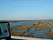 1979 Ford Ranchero - A white vehicle's side mirror shows a reflection of a marshy landscape with a waterway.