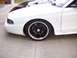 1997 Ford Mustang - Close-up of the front passenger side wheel and fender of a white 1997 Ford Mustang.