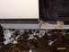 1988 Ford Bronco - Vehicle door sill shows significant rust damage, with snow and debris on the ground below.