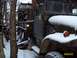 1988 Ford Bronco - A weathered dump truck sits in a snowy, wooded area, showing its age and utility.