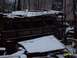 1988 Ford Bronco - An old military truck sits abandoned in the snow, its wooden bed covered by a makeshift tarp.