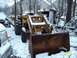 1988 Ford Bronco - A yellow tractor with a front loader sits in the snow, with a partial view of a silver car to its left.