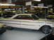 1992 Ford Mustang - A white two-door hardtop car is parked indoors among other vehicles.