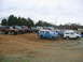 1992 Ford Mustang - A collection of Ford Broncos are gathered on a dirt lot under an overcast sky.