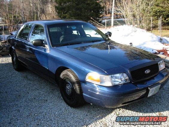 Blue 2003 Ford Crown Victoria front quarter view with black grille and steel wheels
