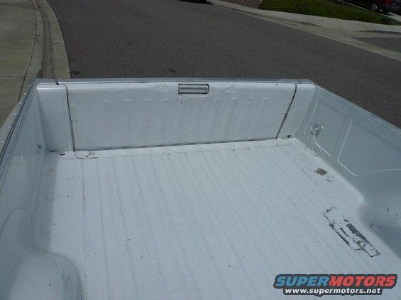 White pickup truck bed interior with ribbed floor and tie-down points