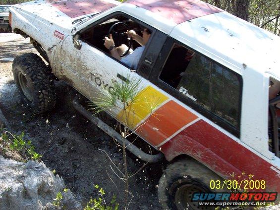 White Toyota 4Runner with red and yellow stripes, off-roading