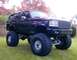 1994 Ford Bronco - This heavily modified Ford Bronco features oversized tires and a lifted suspension, with its grille suggesting a 1994 model year.