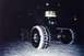 1994 Ford Bronco - A heavily modified truck with large, snow-covered tires sits in a snowy landscape after dark.