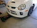 1996 Ford Probe - The front of a white Dodge Neon SRT-4 is shown with a floor jack positioned underneath the front bumper.