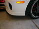 1996 Ford Probe - Close-up of a white sports car's front corner, showing the bumper, wheel, and tire.