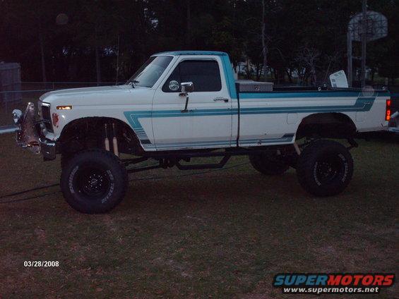 Lifted white pickup truck with blue trim and large tires
