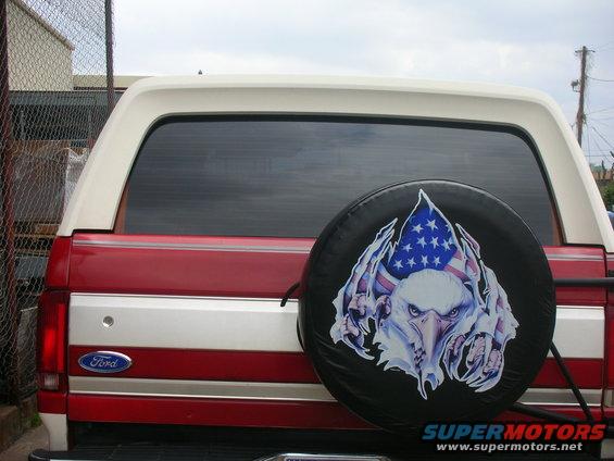 Red and white Ford Bronco rear with spare tire cover an eagle and American flag