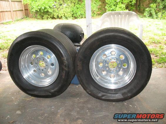 Two drag racing tires mounted on polished aluminum wheels