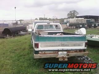 Two-tone green and white 1973-1980 Chevrolet Cheyenne pickup truck, rear view, showing rust on bumper and tailgate