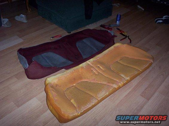 Car seat cushions and fabric laid out on a wooden floor, with tools nearby