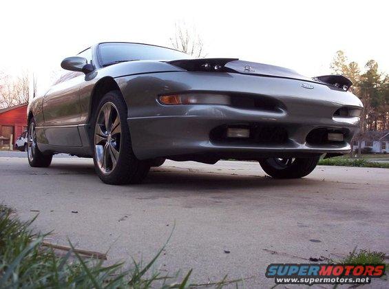 Gray Ford Probe from a low front angle. It has aftermarket wheels and a hood scoop