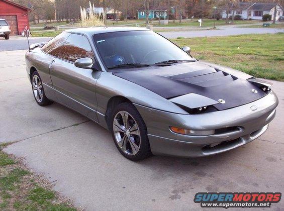 1995 Ford Probe with black aftermarket hood and custom wheels parked on a driveway