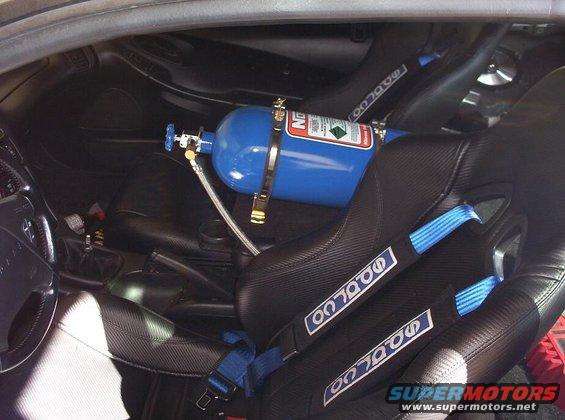 Car interior with racing seats and a blue nitrous oxide tank mounted between them