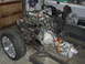 1964 Ford Ranchero - This is an engine and transmission assembly mounted on a custom metal frame, with one wheel attached.