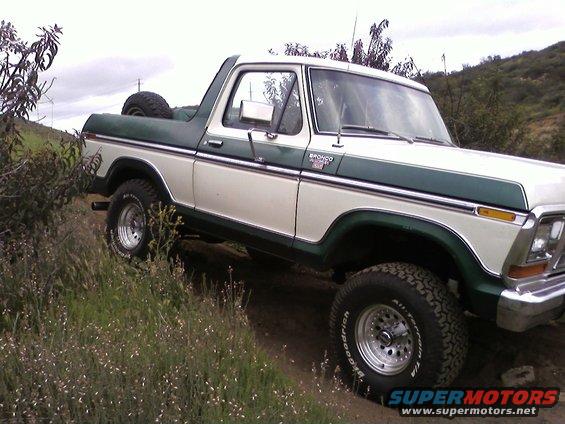 1978 Ford Bronco on a dirt trail with green and white paint
