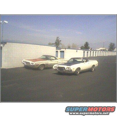 1972 Ford Ranchero and another pickup truck parked in front of storage units