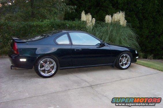 Dark green Honda Prelude coupe with aftermarket wheels parked on a concrete driveway