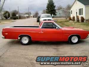 Red 1969 Ford Ranchero pickup truck, side view. White wheels, black interior