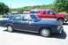 1991 Mercury Marquis - A 1991 Mercury Marquis sedan is parked next to a red Ford pickup truck, with a police car in the background.