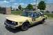 1991 Mercury Marquis - A 1991 Mercury Marquis sedan with a distinctive yellow and black paint scheme is parked in a lot.