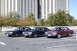 1991 Mercury Marquis - Three sedans are parked in a lot in front of a modern building. The maroon car appears to be a 1980s Ford LTD Crown Victoria.
