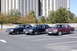 1991 Mercury Marquis - Three sedans are parked in a lot, with a large building in the background.