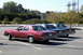 1991 Mercury Marquis - Three sedans are parked in a lot under a clear sky.