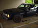 1991 Mercury Marquis - This dark sedan is parked under a covered area, showing its front quarter with the hood slightly ajar.
