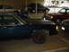 1991 Mercury Marquis - A dark blue sedan is parked in a lot with other vehicles and a motorcycle.