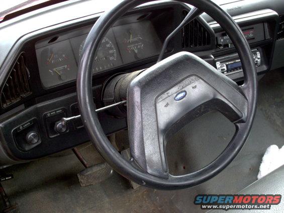 Interior view of a Ford truck showing steering wheel, dashboard gauges, and radio