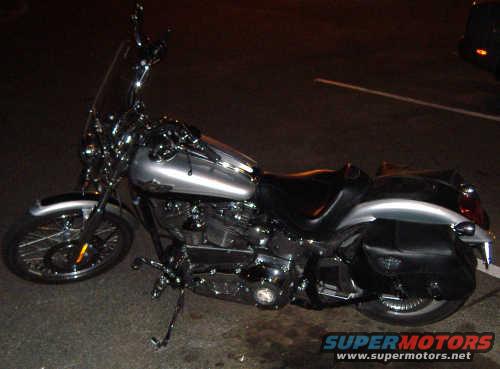 Silver 2003 Harley-Davidson Softail motorcycle with black saddlebags, viewed from the side