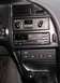 1994 Ford Thunderbird - Close-up of a car's dashboard, showing the climate control system, radio, and gear shifter.