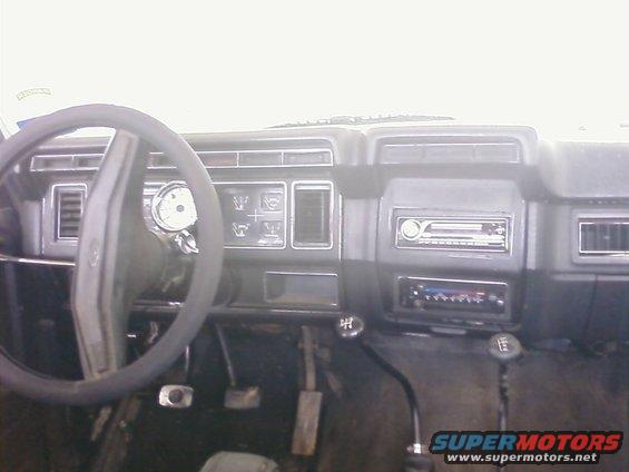 Dashboard view of a vehicle, showing steering wheel, gauges, radio, and gear shifters