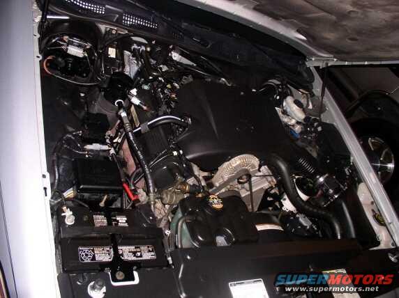 Engine bay with dual batteries and complex wiring, viewed from above